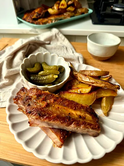 Roasted marinated pork ribs served with crispy golden potato wedges